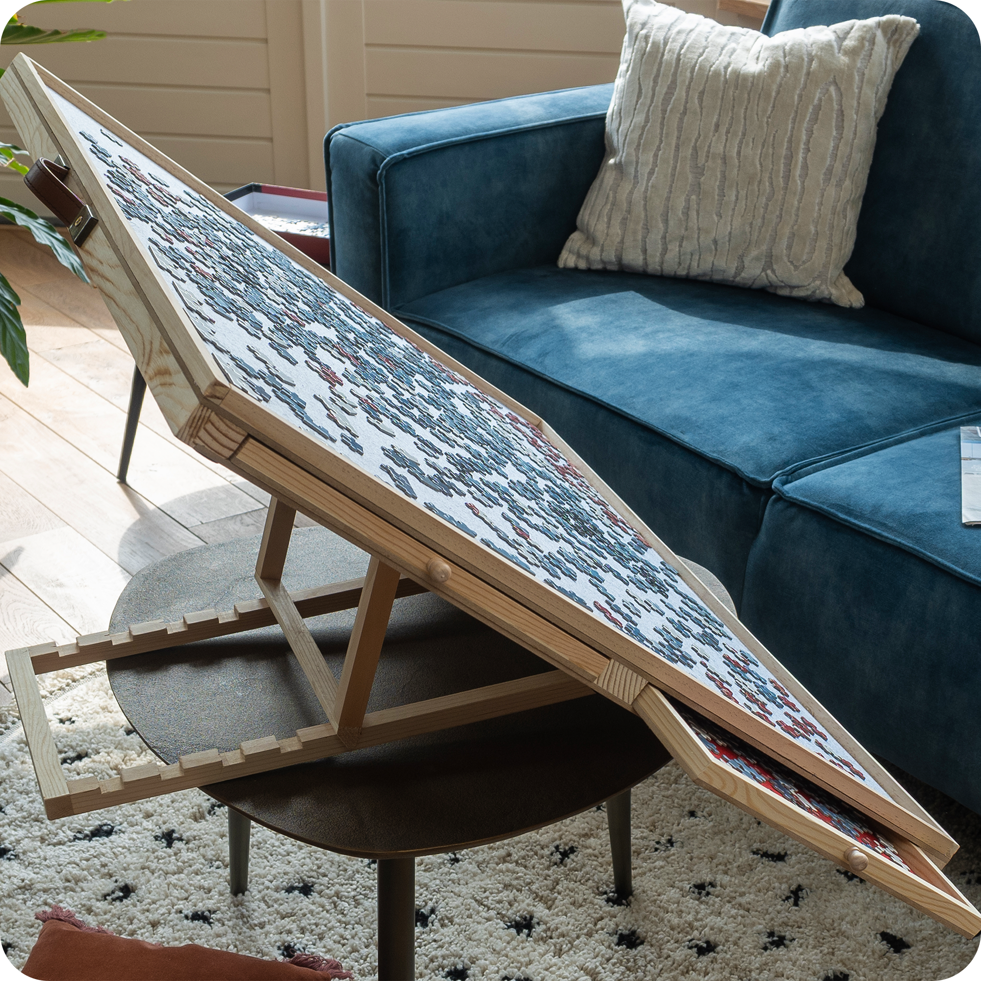 Een landelijke woonkamer waar de verstelbare puzzelplaat staat op een salontafel. Je ziet de puzzelstukjes op de puzzelplaat liggen die ervoor zorgen dat ze er niet af vallen.